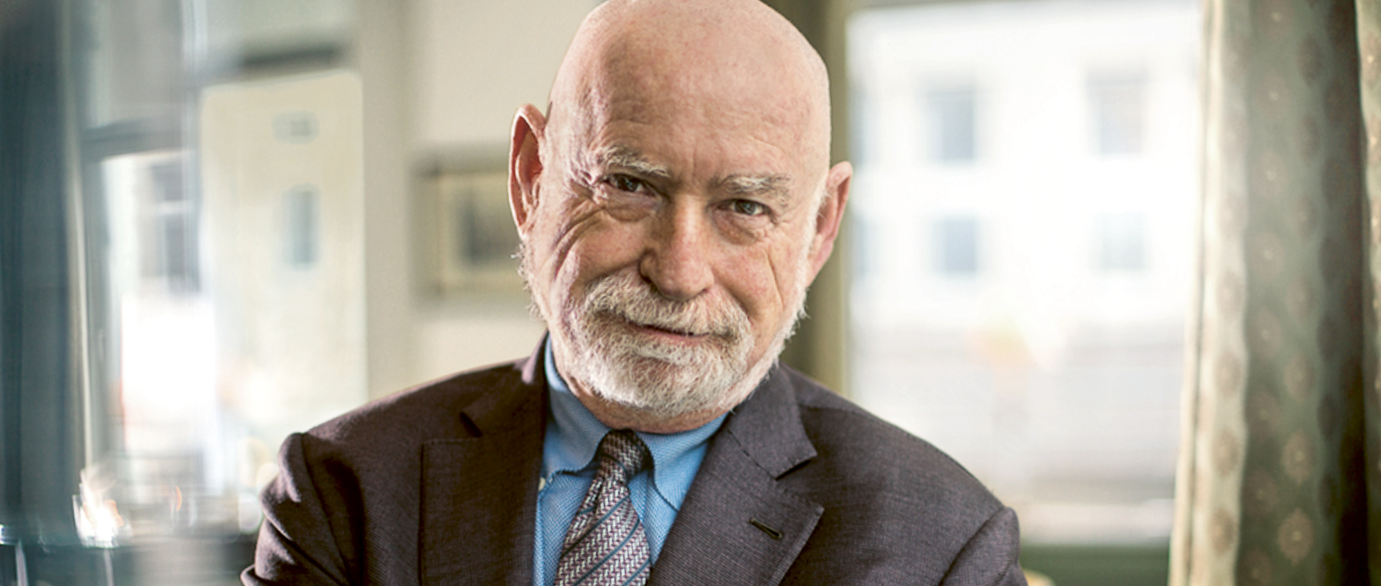 Portrait of Peter Schwartz, an elderly gentleman with little hair, beard, dressed in a suit.