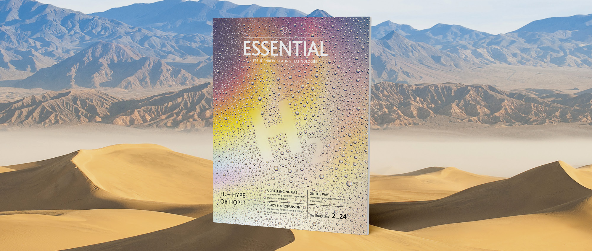 The Essential Edition H2 in rainbow colours stands in a desert. 