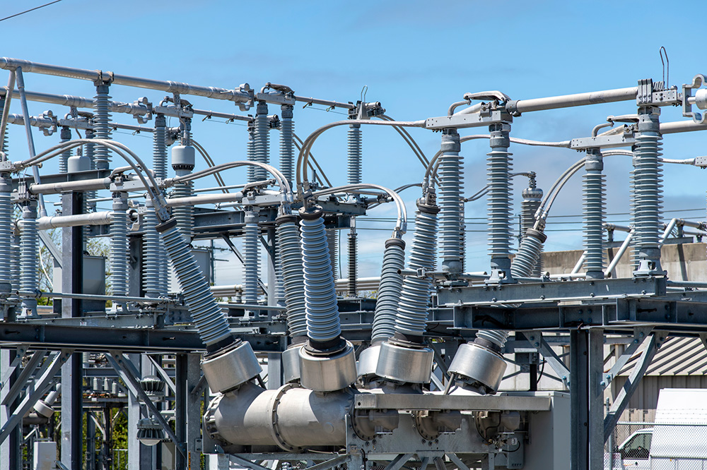 High-voltage electrical substation with insulators and power lines.
