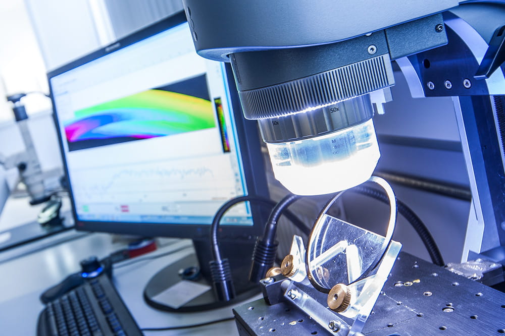 A close-up of a high-tech laboratory setup with precision instruments, a computer displaying colorful data curves.
