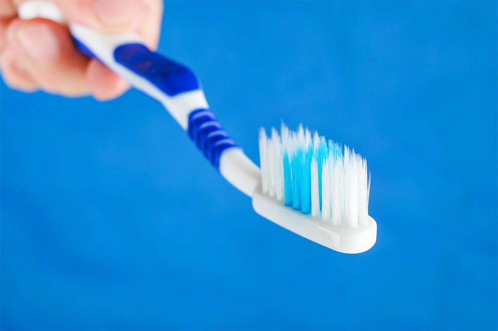Hand mit Plastikzahnbürste