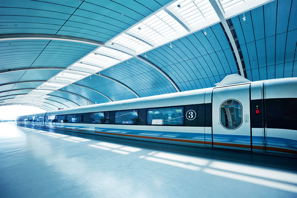 Zug im überdachten Bahnhof hält an einem Gleis