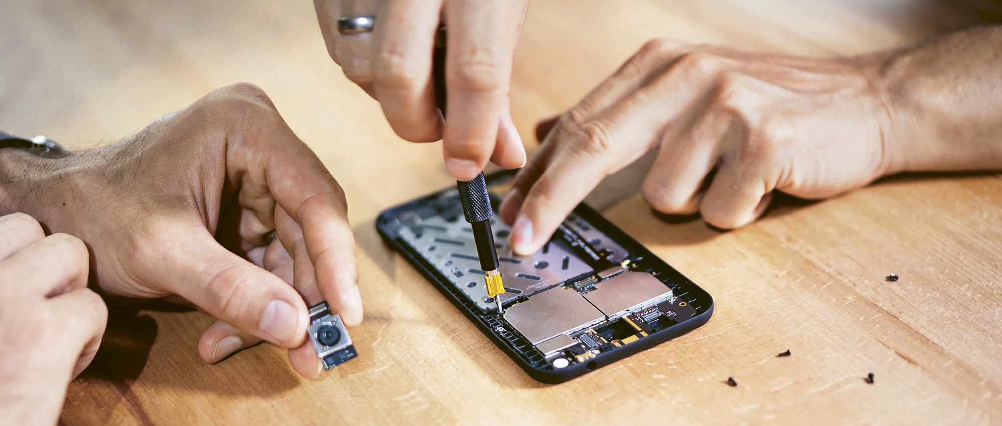 Hände nehmen ein Handy von Shift auseinander.