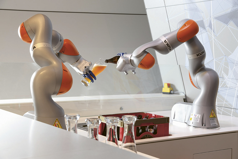 Zwei Roboterarme schenken ein Bier in ein Glas ein