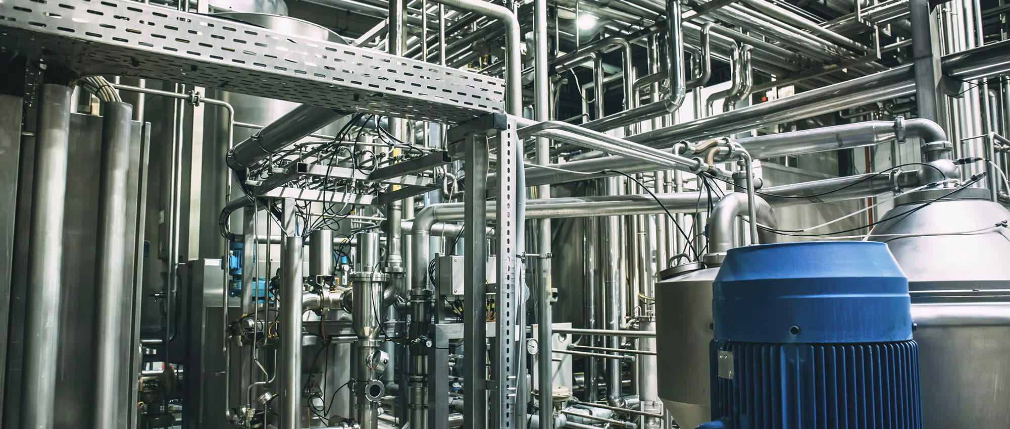 Eine Produktionsanlagen in der Prozessindustrie mit zahlreichen Pumpen, Tanks, Ventile, Rohre und Leitungen.