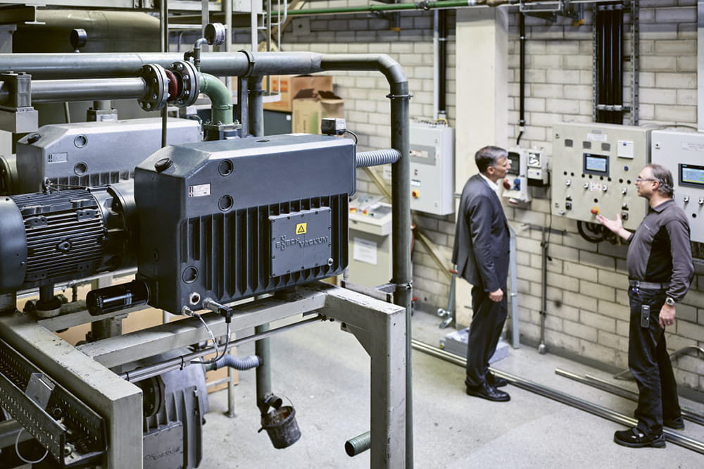 Zwei Männer schauen sich Kompressoren in einer Fabrik an.