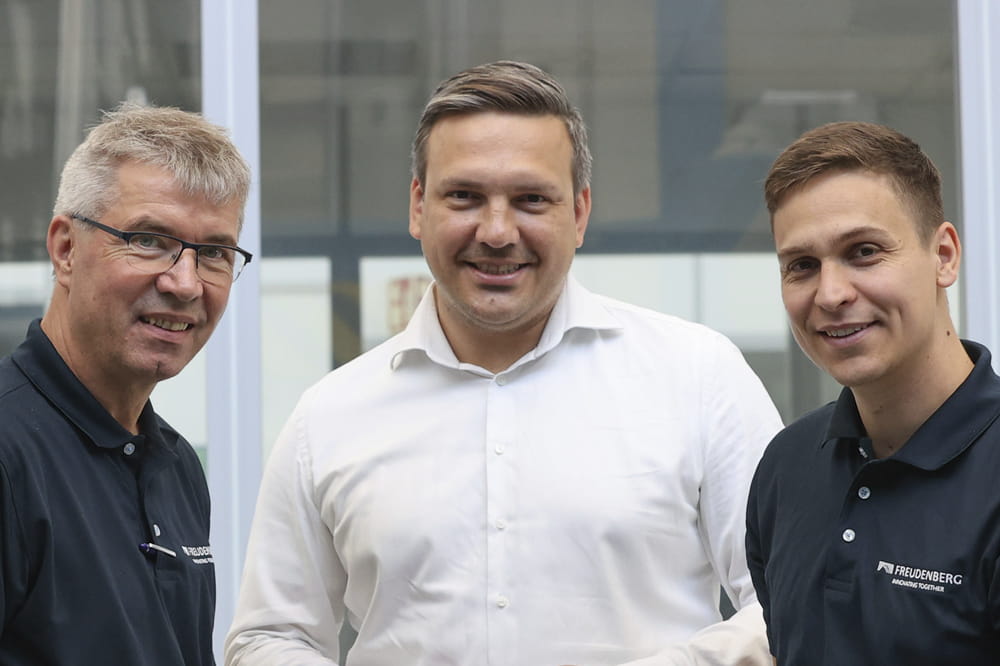 3 Männer lächeln in die Kamera.
