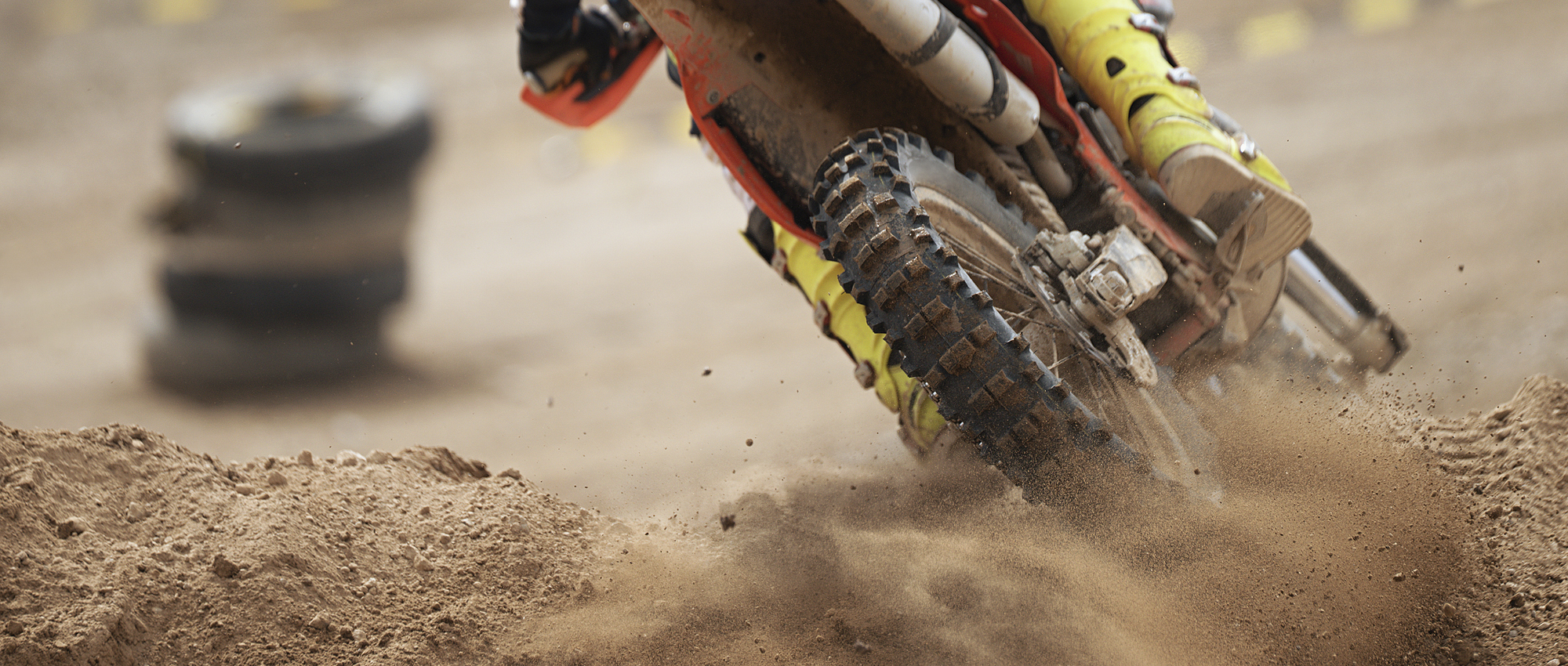 Ein Motorcross-Motorrad fährt über Sand.