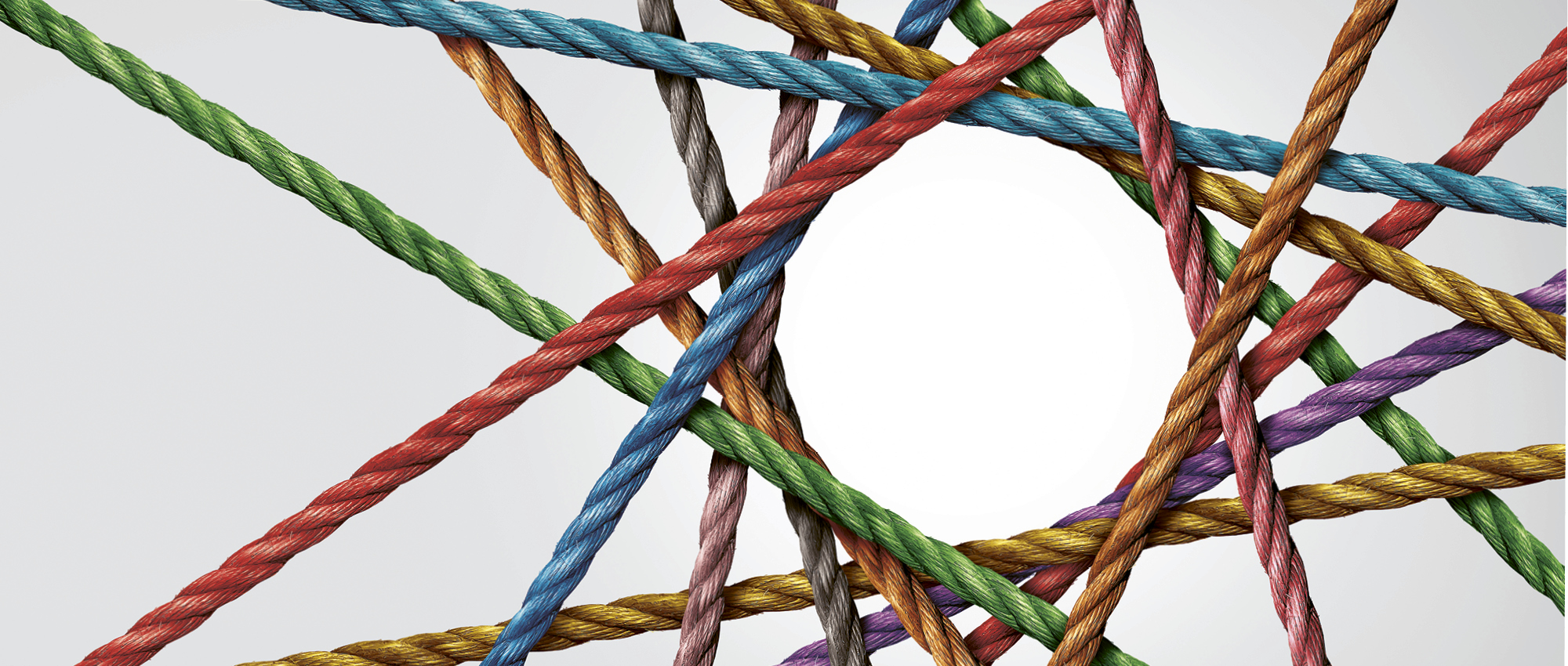 Ein Netz aus verschiedenfarbigen Seilen, die einen Kreis in der Mitte bilden. Copyright: iStock/wildpixe
