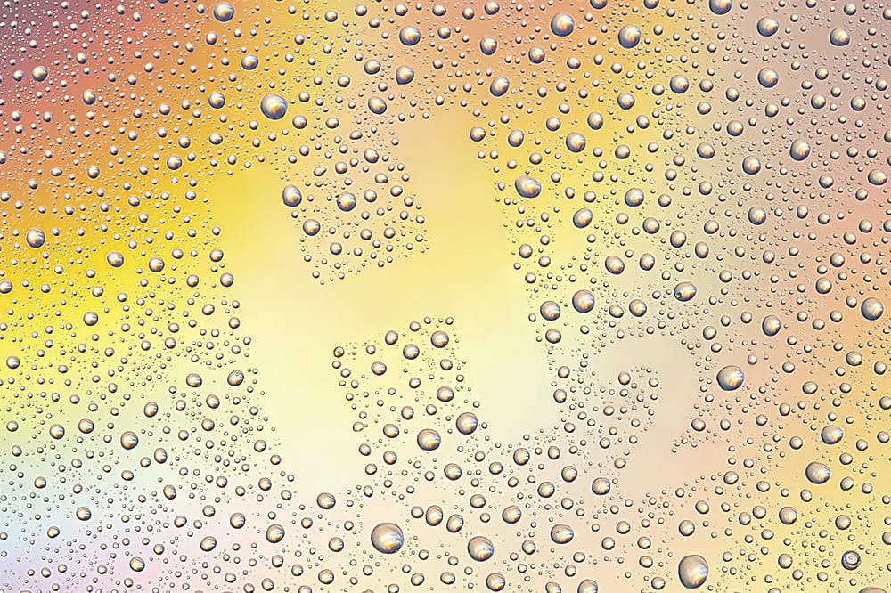 Regenbogenfarbener Hintergrund auf dem Wassertropfen abgebildet sind, die eine Fläche freilassen, die den Schriftzug H2 ergibt.
