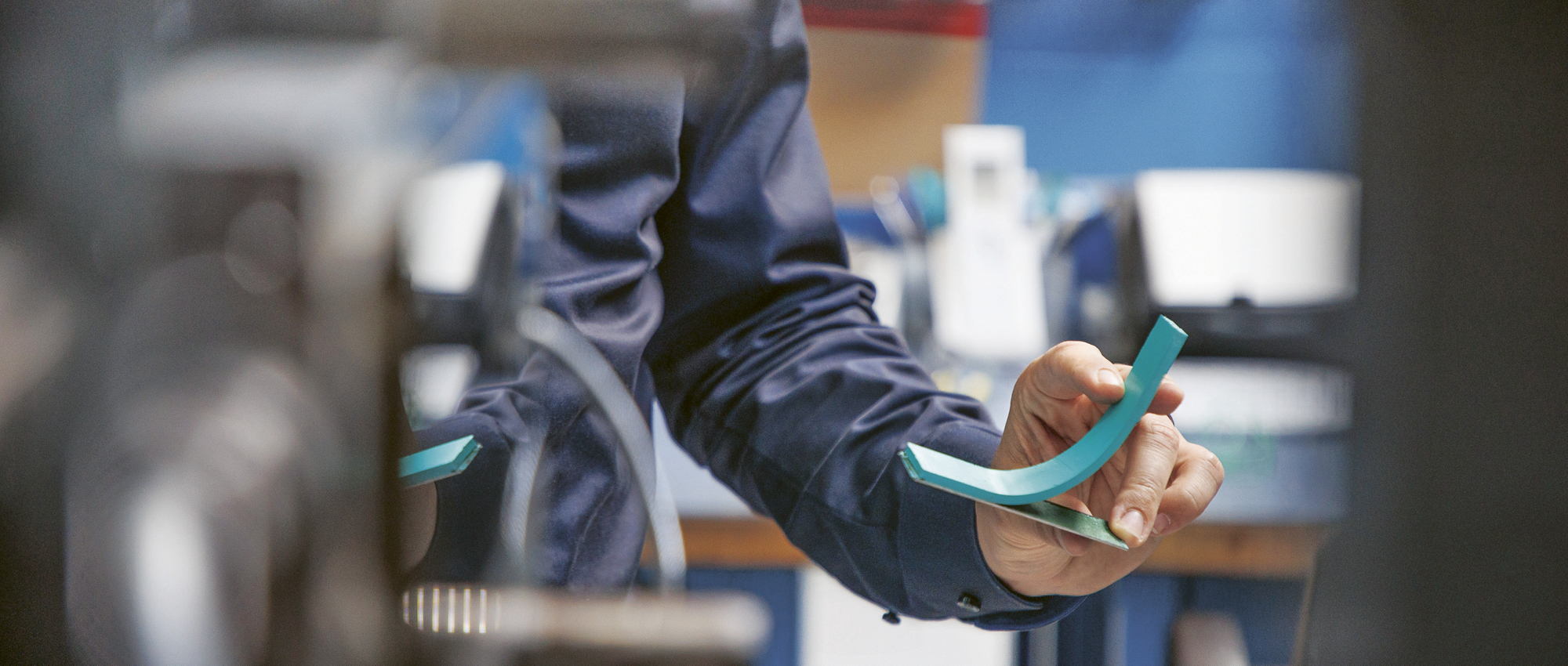 Prüfkörper eines Blauen Elastomers verbunden mit einer Metallplatte.