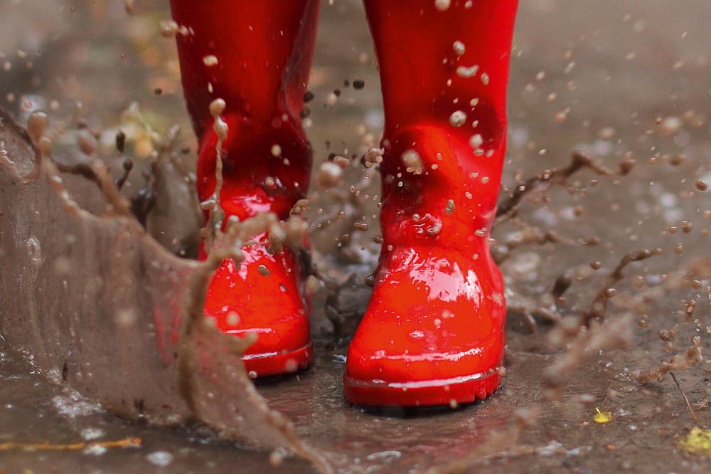 Rote Gummistiefel im Matsch